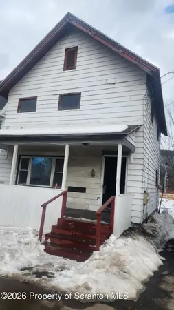 a view of a white house next to a road