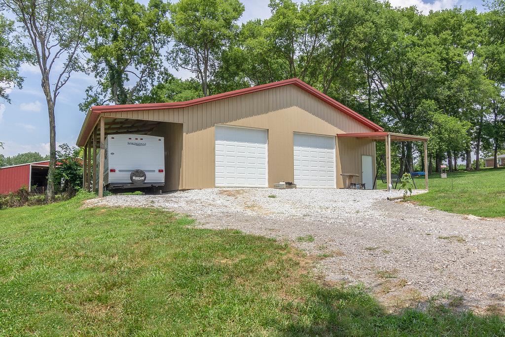 72 Vantrease Road Brush Creek, TN 38547 - Photo 22 of 25 double garage doors and covered area for vehicles with pedestrian door