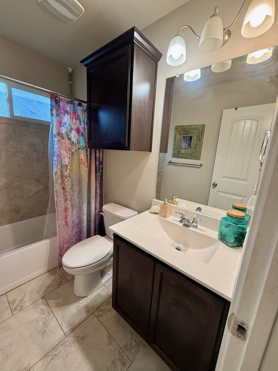930 Pumpkin Ridge New Braunfels, TX 78130 - Photo 16 of 32 Bathroom featuring a dark wood-finish vanity with an integrated sink, a matching dark wood-finish overhead cabinet, and a full-width mirror