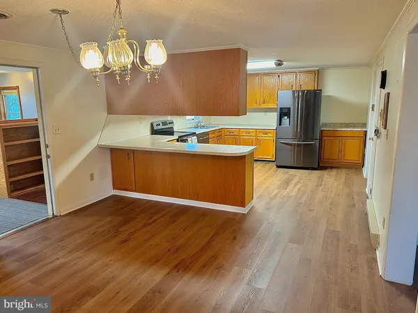 a view of a kitchen with wooden floor and a refrigerator