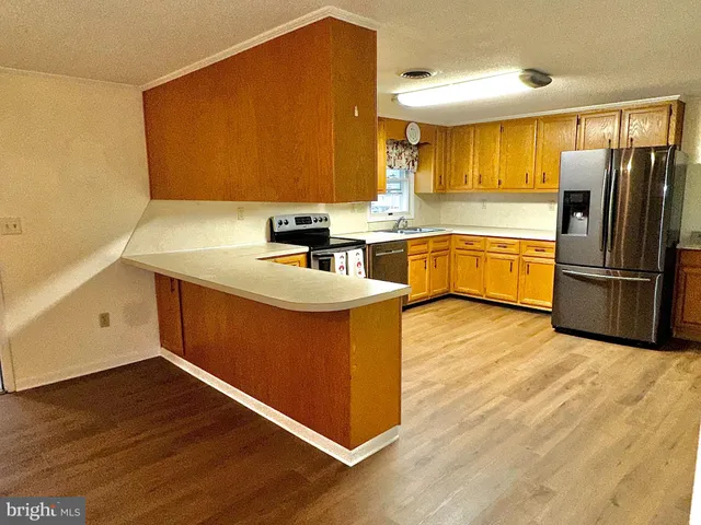a kitchen with wooden floors and wooden cabinets