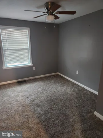 en empty room with windows and fan