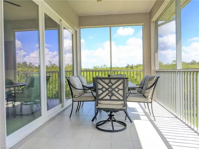 a view of a chairs and table in patio with a balcony