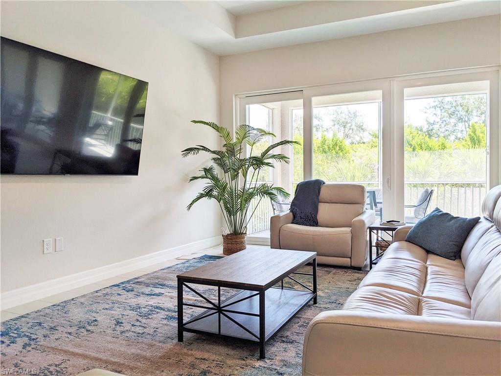 178 Indies Drive East, Unit 201 Naples, FL 34114 - Photo 4 of 31 a living room with furniture and a flat screen tv