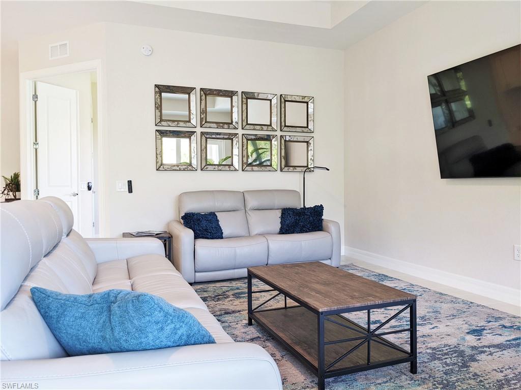 178 Indies Drive East, Unit 201 Naples, FL 34114 - Photo 5 of 31 a living room with furniture and a flat screen tv