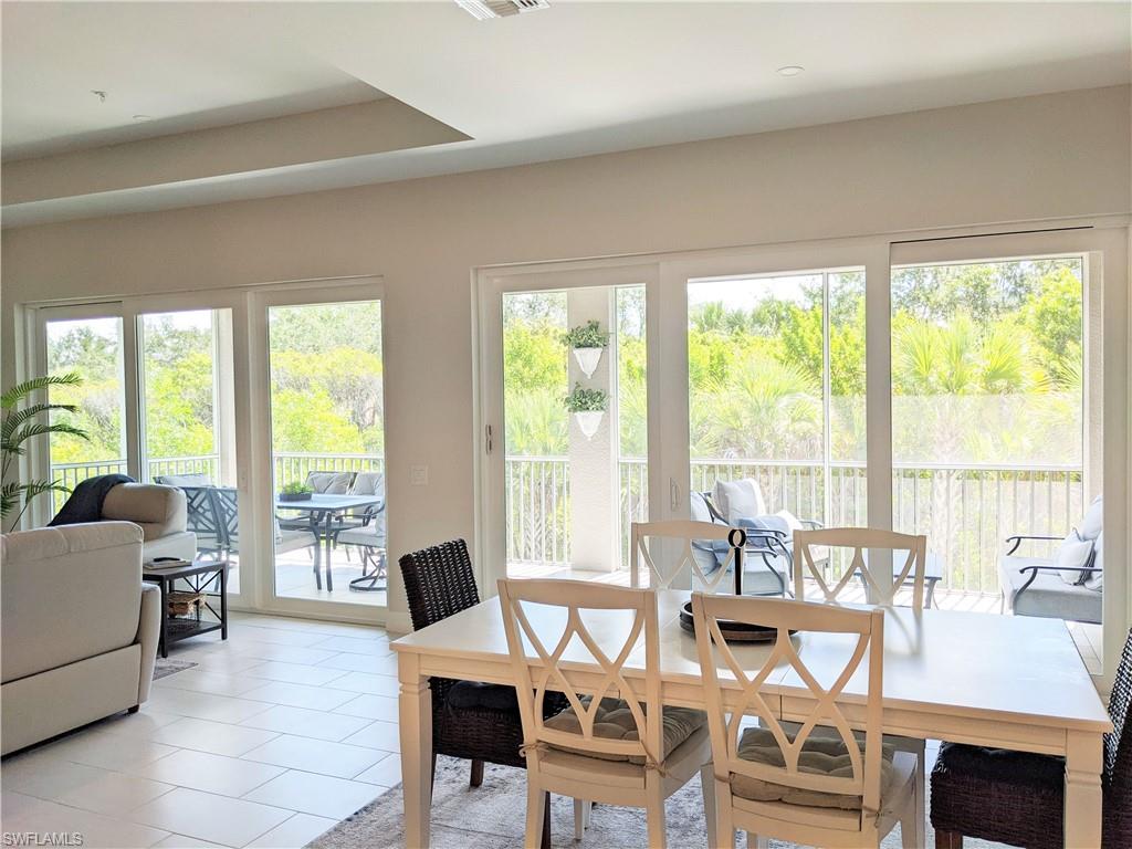 178 Indies Drive East, Unit 201 Naples, FL 34114 - Photo 9 of 31 a living room with furniture and large windows