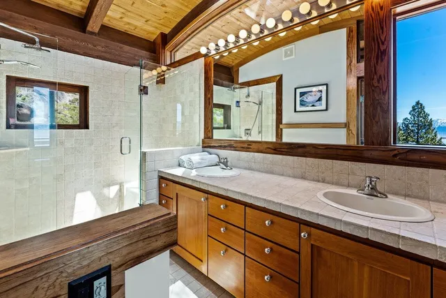 a spacious bathroom with a granite countertop sink mirror and a shower