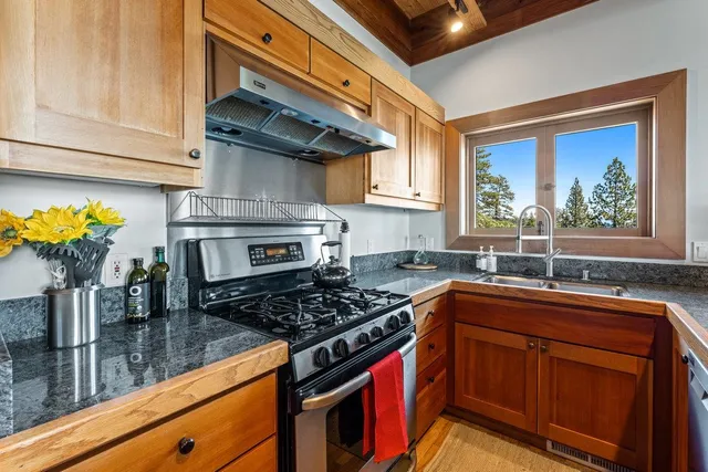 a kitchen with stainless steel appliances granite countertop a stove a sink and a microwave