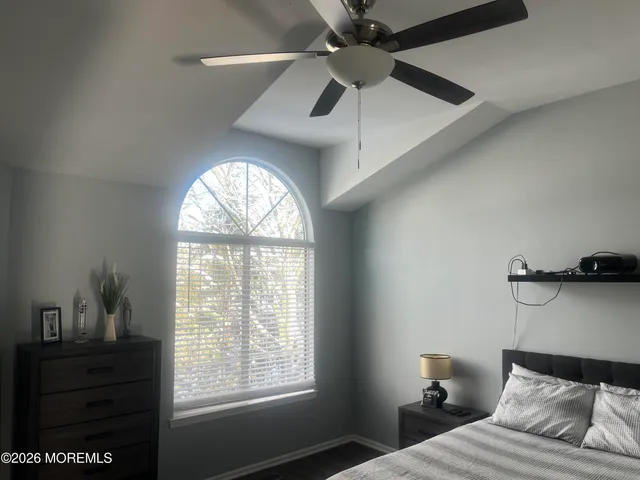 a bedroom with a bed and a ceiling fan
