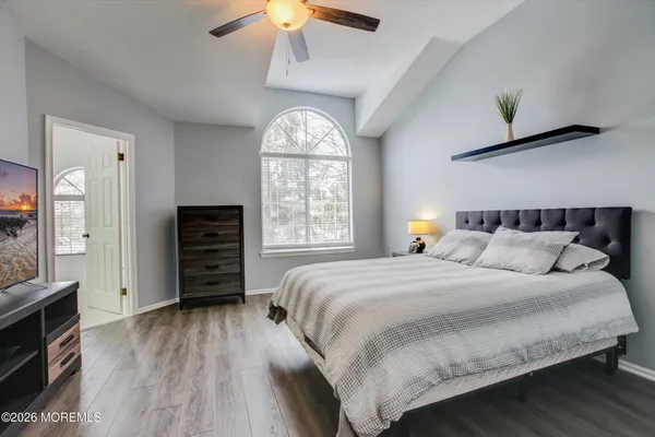 a bedroom with a bed and wooden floor