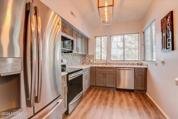a kitchen with stainless steel appliances granite countertop a stove a sink and a refrigerator