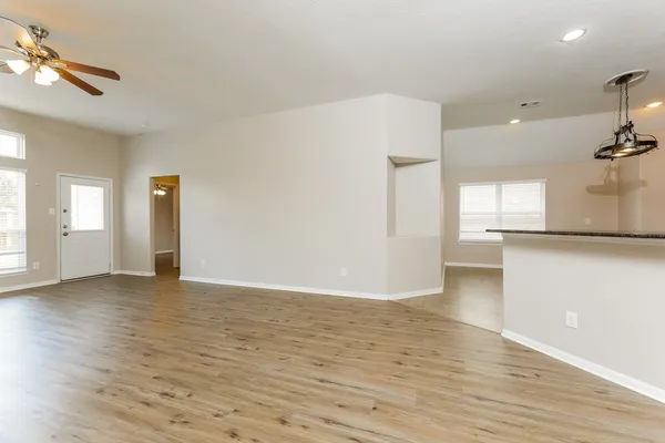 a view of a kitchen with a fridge and wooden floor