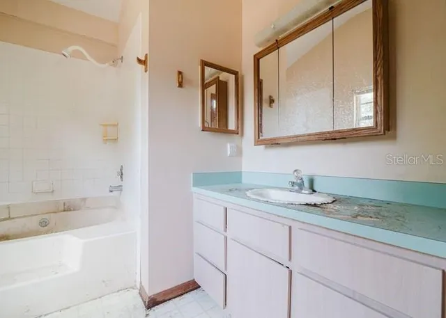 a bathroom with a sink a toilet a tub and shower