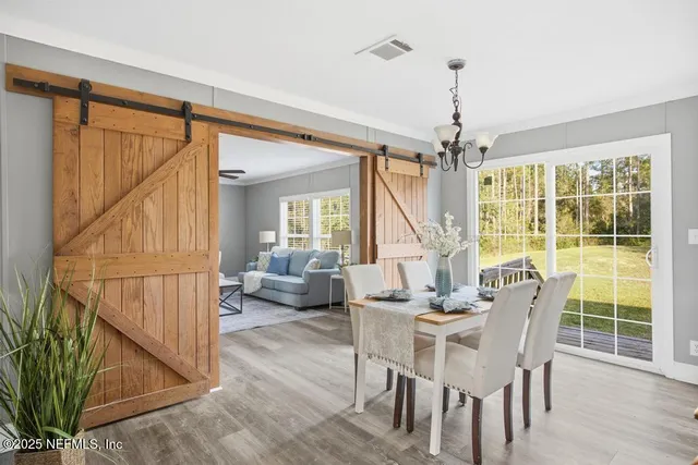 a dining room with furniture a chandelier and wooden floor