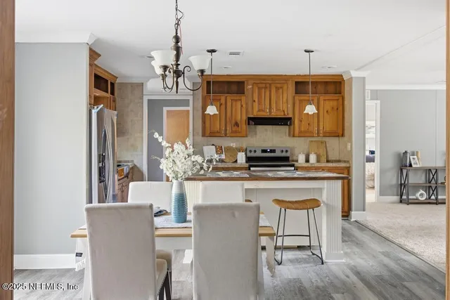 a kitchen with kitchen island granite countertop a sink cabinets and wooden floor
