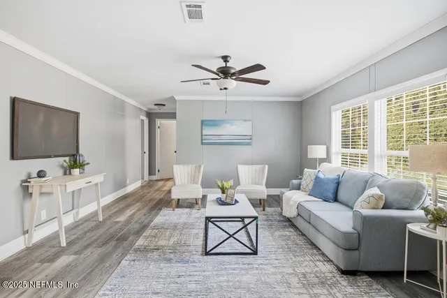 a living room with furniture a flat screen tv and a large window