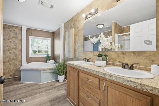 a bathroom with a granite countertop sink mirror and a bathtub