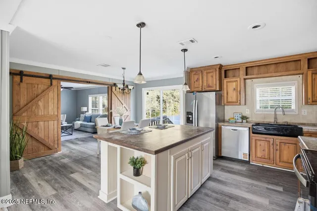 a kitchen with stainless steel appliances granite countertop a sink and a wooden floors