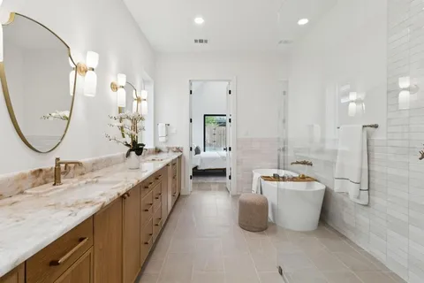 a spacious bathroom with a tub sink and mirror
