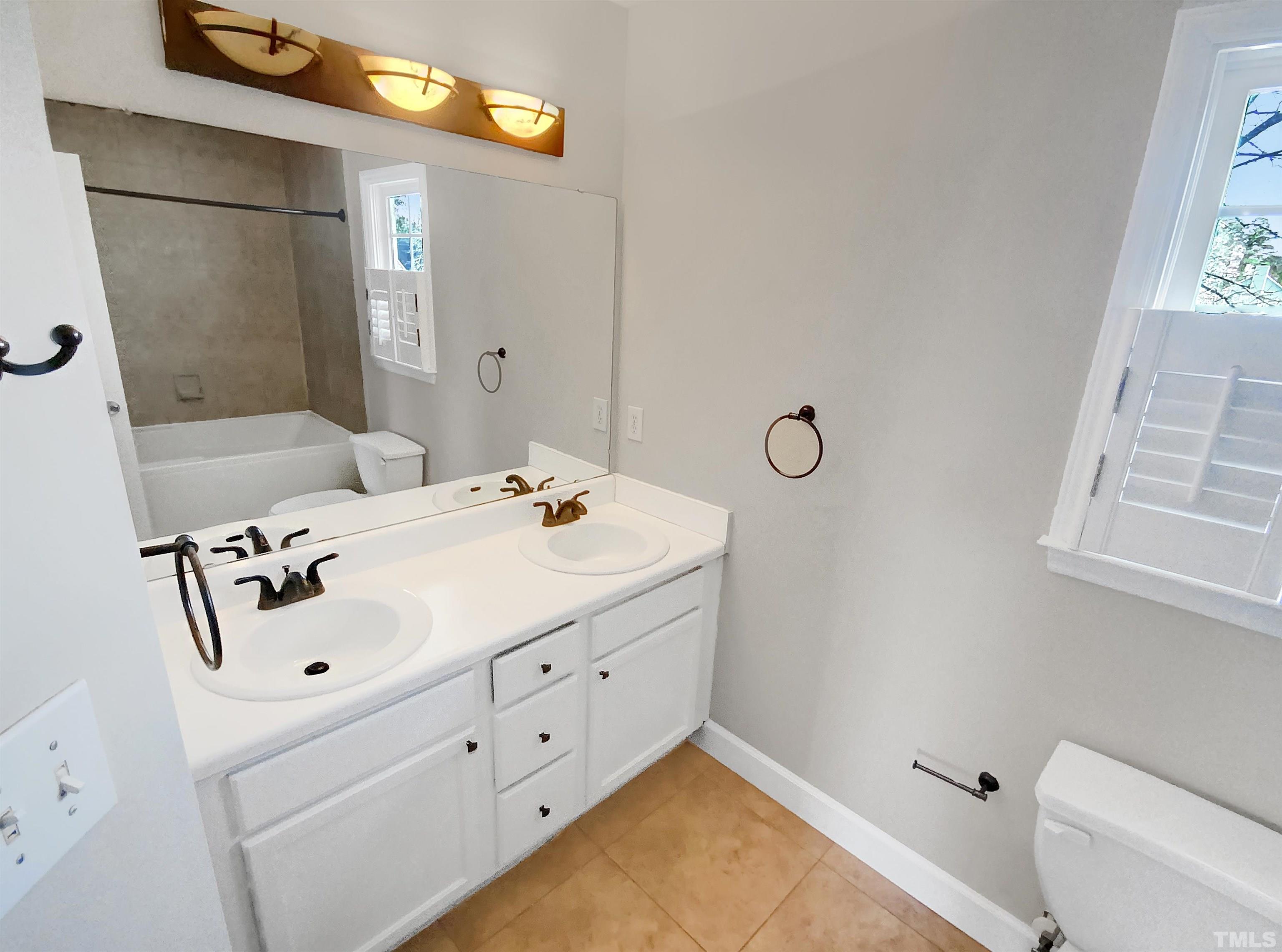 3216 Leebrook Road Raleigh, NC 27616 - Photo 11 of 17 a bathroom with a tub sink vanity and mirror