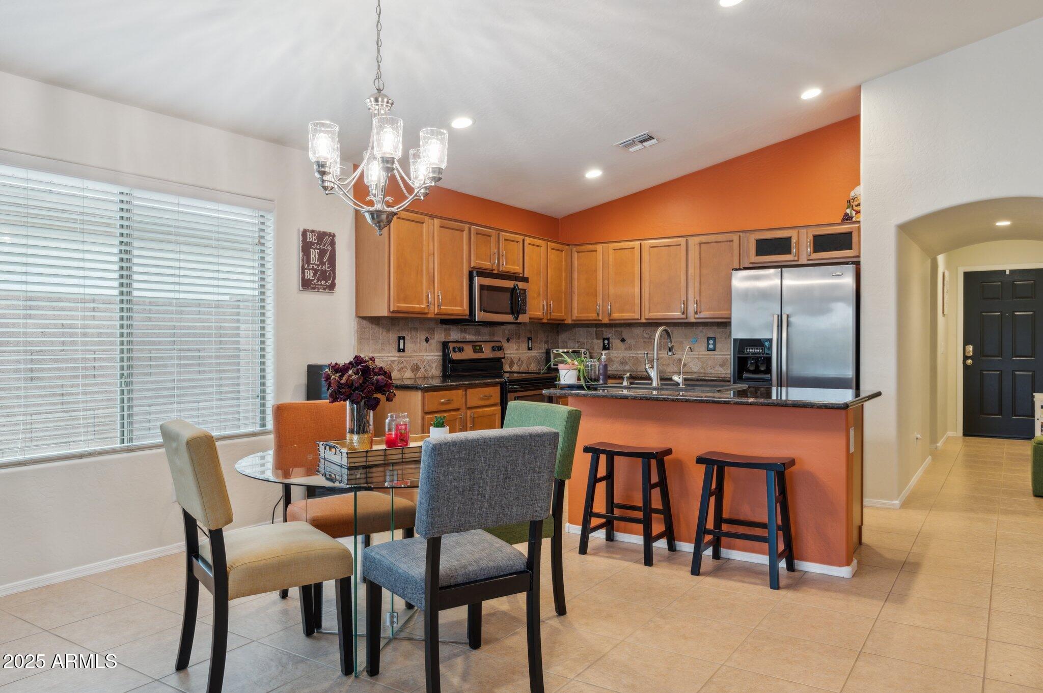 411 West Gascon Road San Tan Valley, AZ 85143 - Photo 3 of 30 a dining room with stainless steel appliances a dining table chairs and a refrigerator