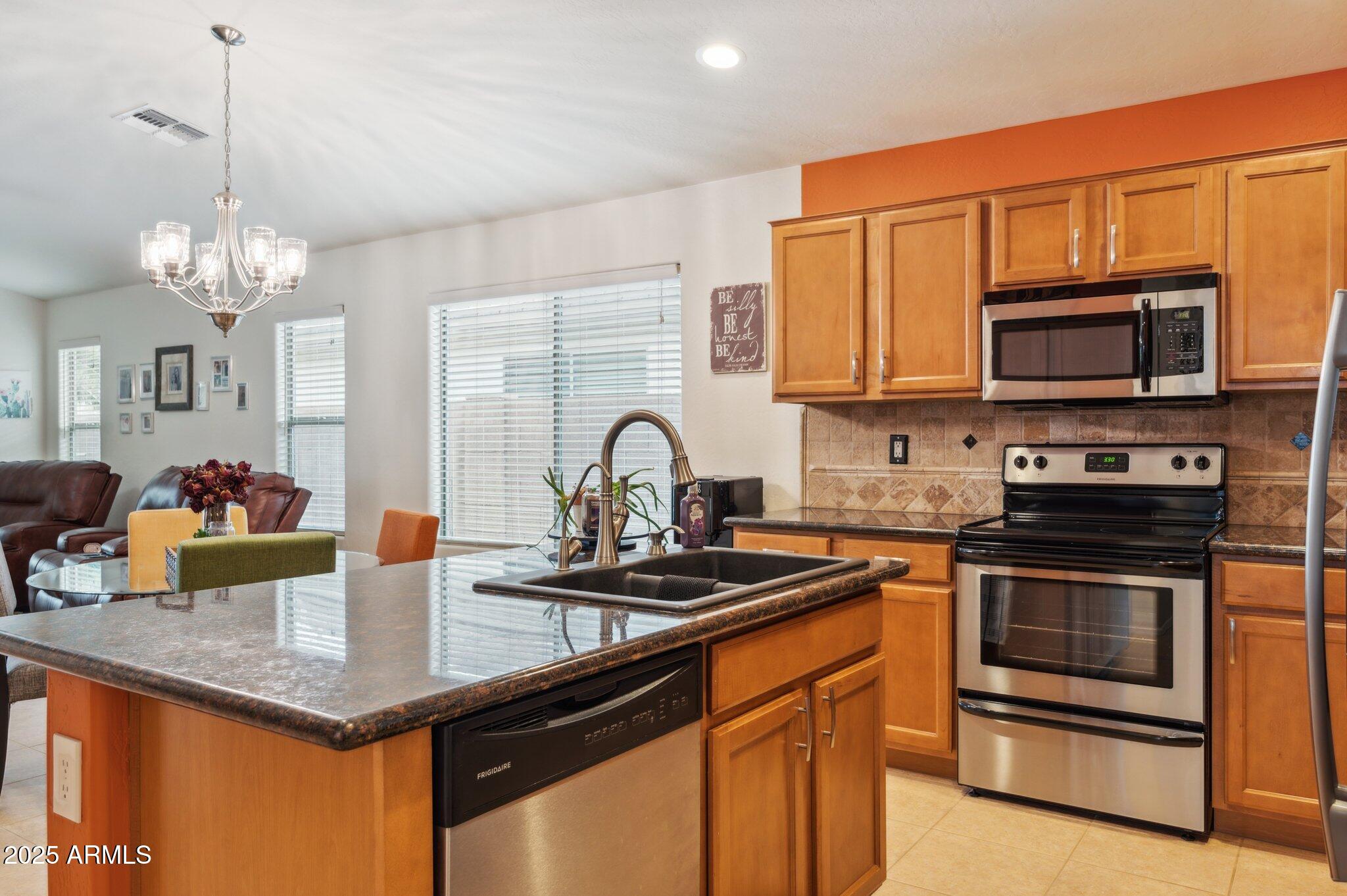 411 West Gascon Road San Tan Valley, AZ 85143 - Photo 4 of 30 a kitchen with stainless steel appliances granite countertop a stove a sink dishwasher a microwave oven with granite countertops and cabinets