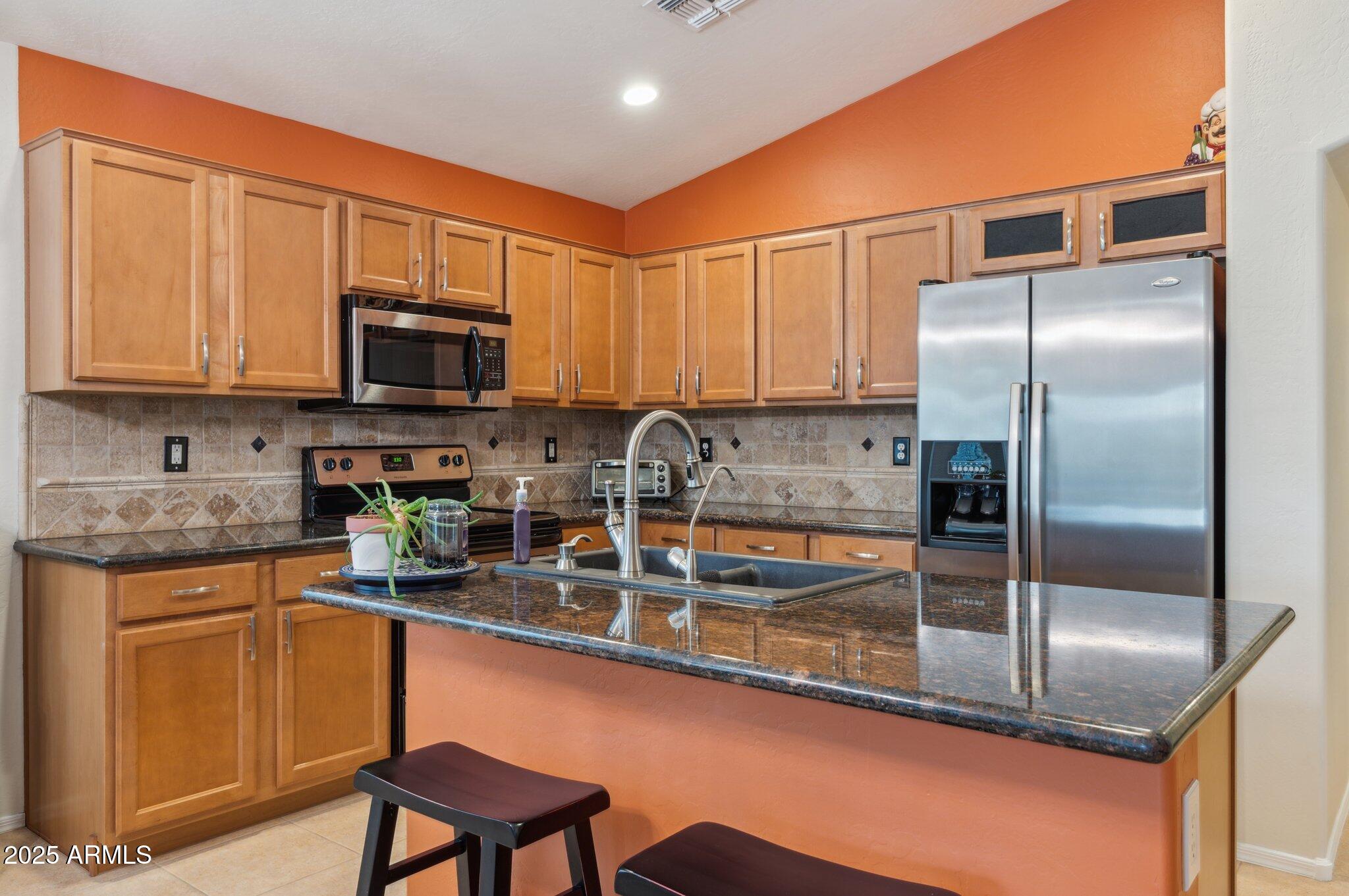 411 West Gascon Road San Tan Valley, AZ 85143 - Photo 5 of 30 a kitchen with stainless steel appliances granite countertop a refrigerator a stove top oven a sink and dishwasher