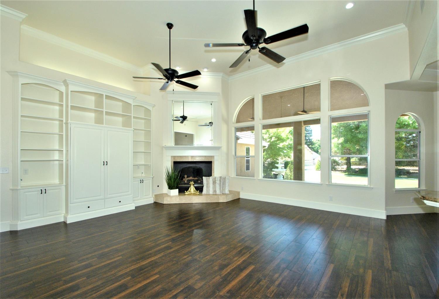 10584 Keats Avenue Clovis, CA 93619 - Photo 16 of 72 an empty room with wooden floor a ceiling fan and windows