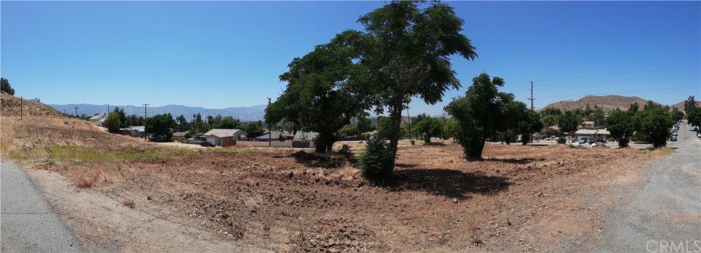 a view of a dirt road with a building in the background