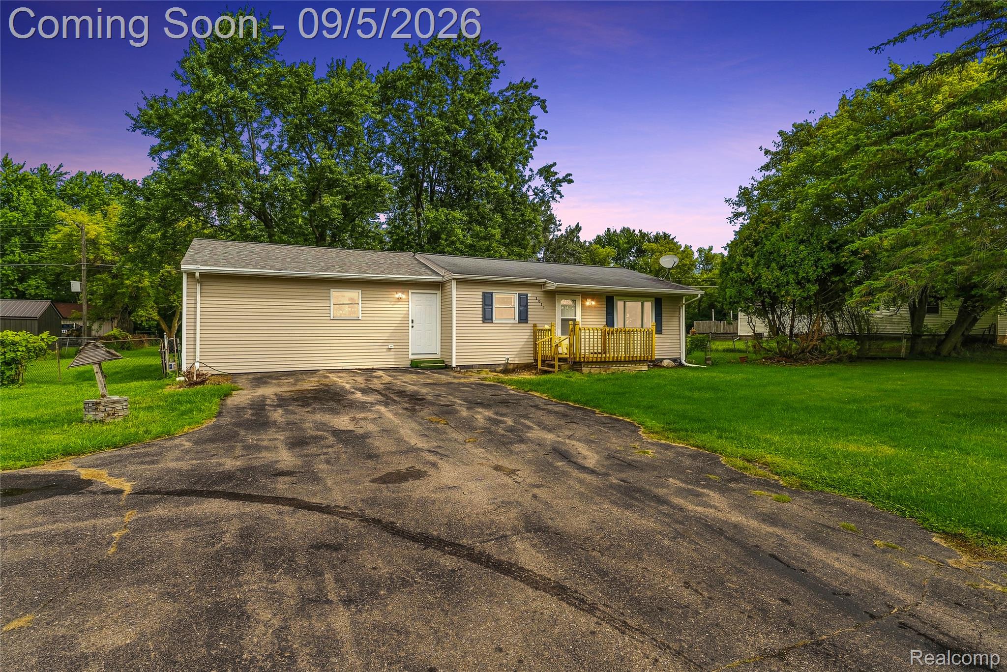 2071 East Dodge Road Clio, MI 48420 - Photo 1 of 38 Single-story property with light-colored siding, a front porch with wooden railings, a paved driveway, and a well-maintained lawn