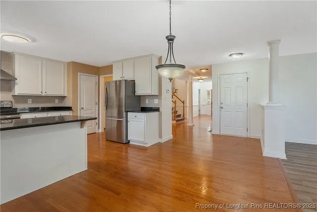 a kitchen with granite countertop stainless steel appliances a refrigerator a stove a microwave and cabinets