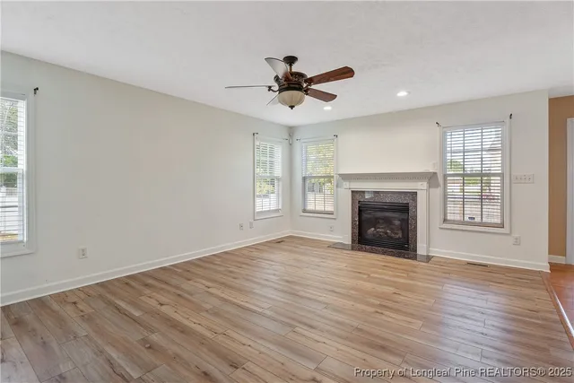 an empty room with windows fireplace and a sink