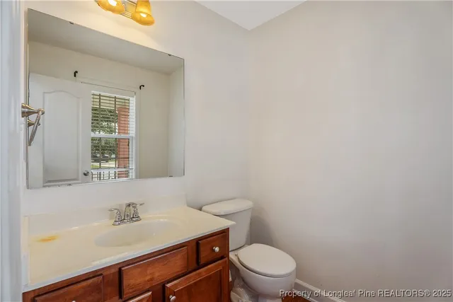a bathroom with a sink a toilet and a window