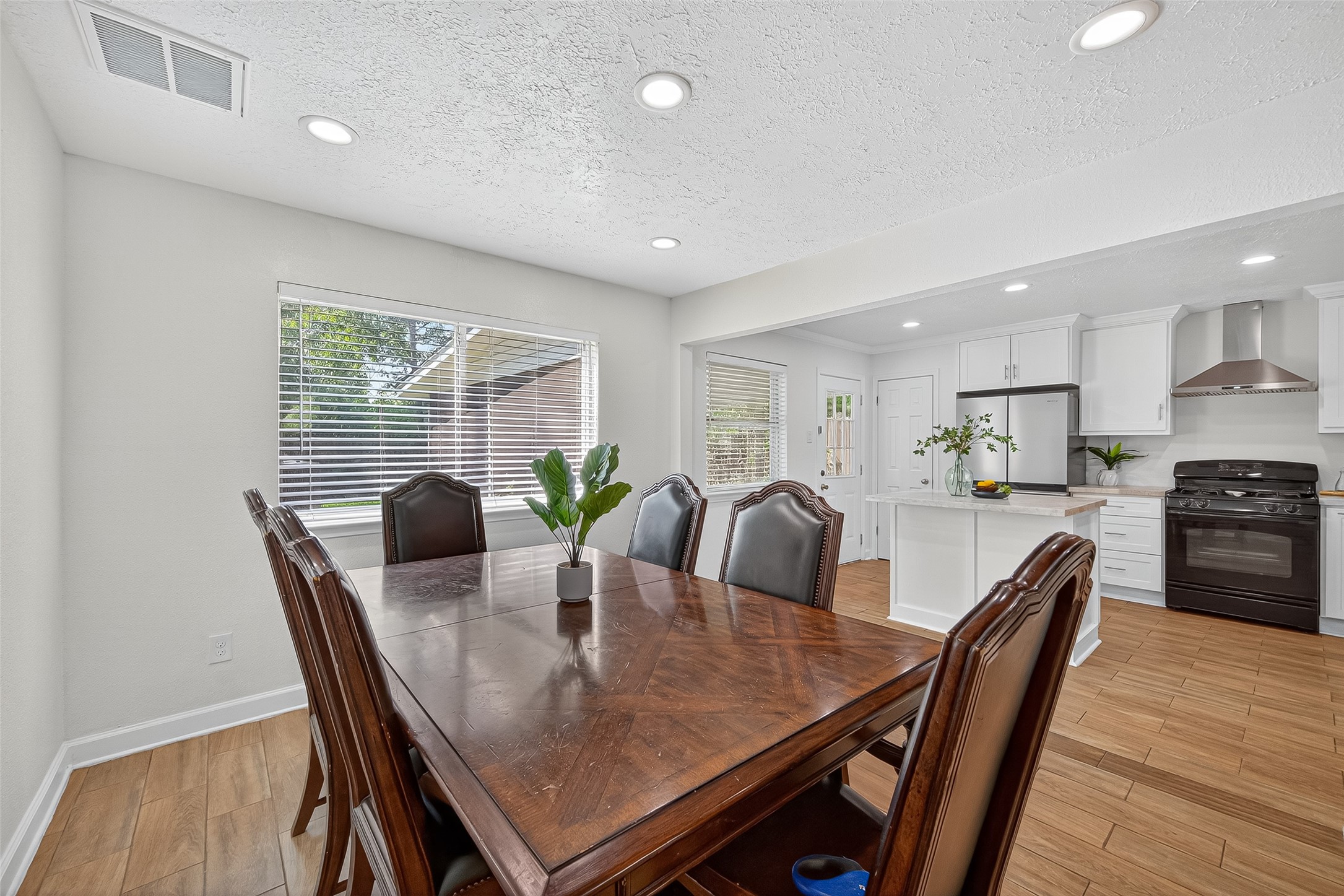 5323 Windsong Trail Houston, TX 77084 - Photo 11 of 30 Seamless flow from the dining area into the kitchen, offering great functionality for entertaining. The oversized window frames views of the backyard, adding light and openness.