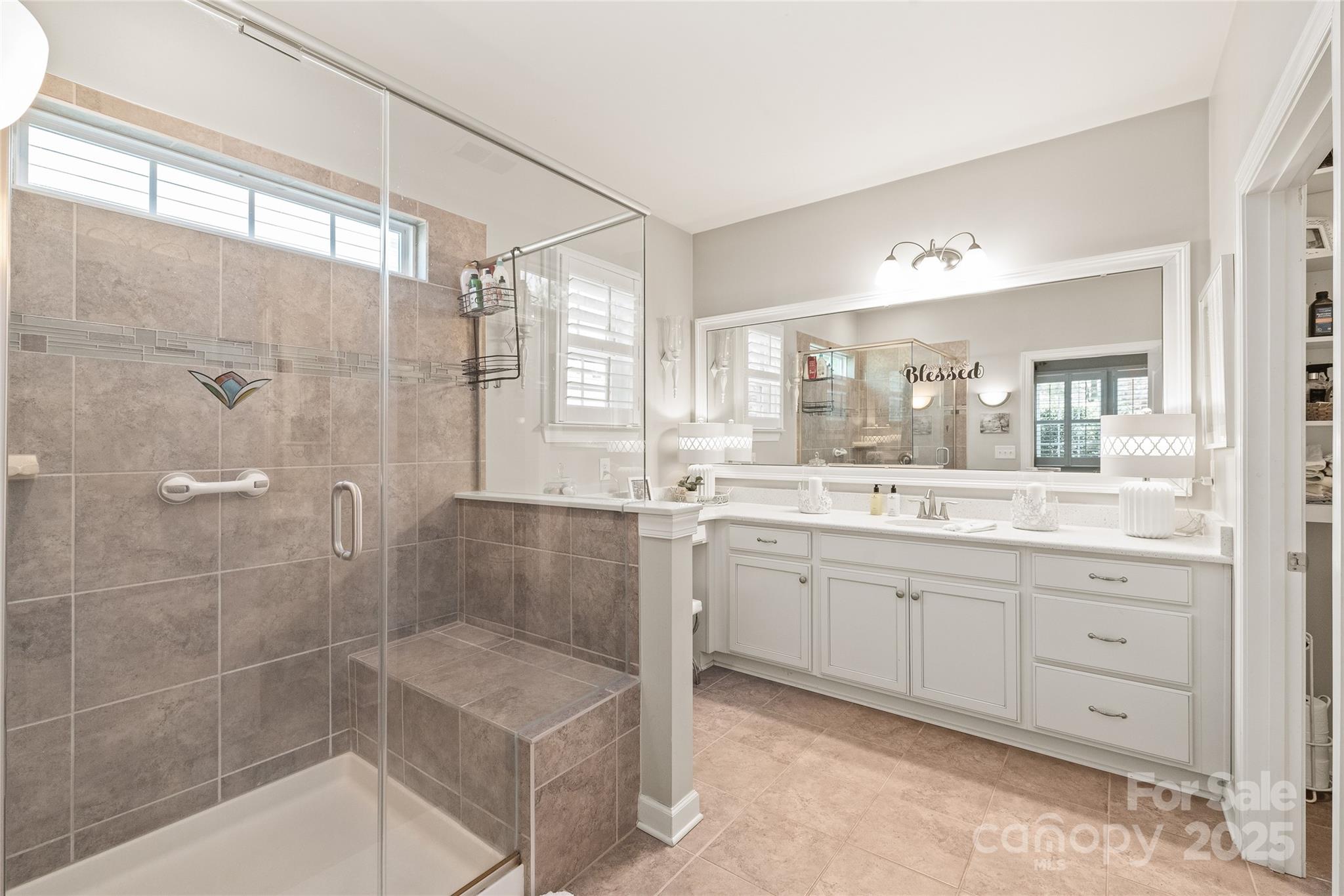 5002 Samoa Ridge Drive Lancaster, SC 29720 - Photo 19 of 45 a bathroom with a granite countertop sink a mirror a bathtub and next to a window