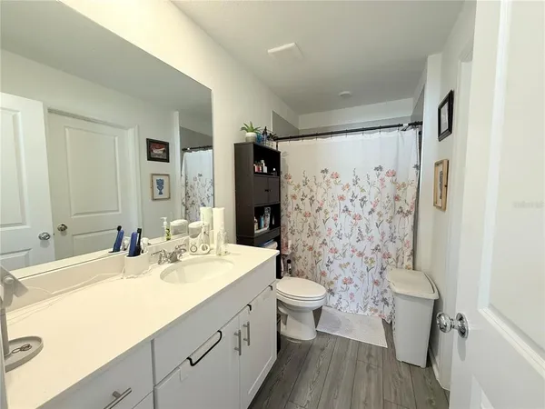 a bathroom with a double vanity sink toilet and shower