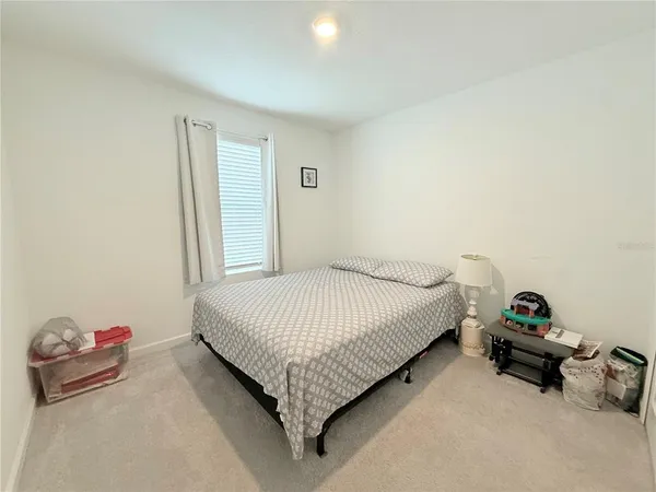 a bed sitting in a bedroom next to a window