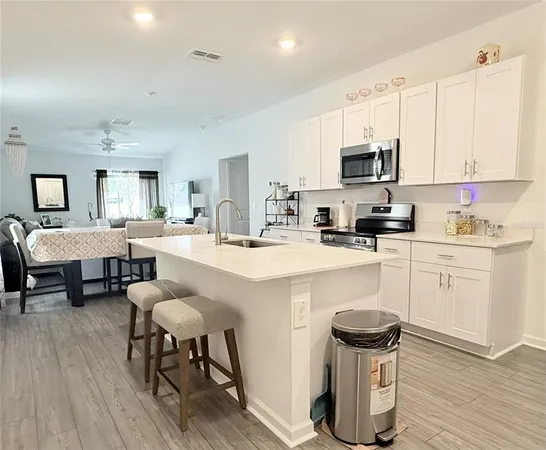 a kitchen with a sink chairs and cabinets