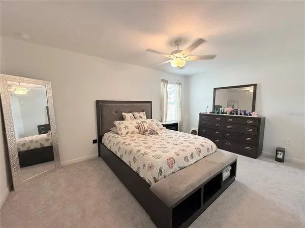 a bedroom with a bed and a lamp on dresser