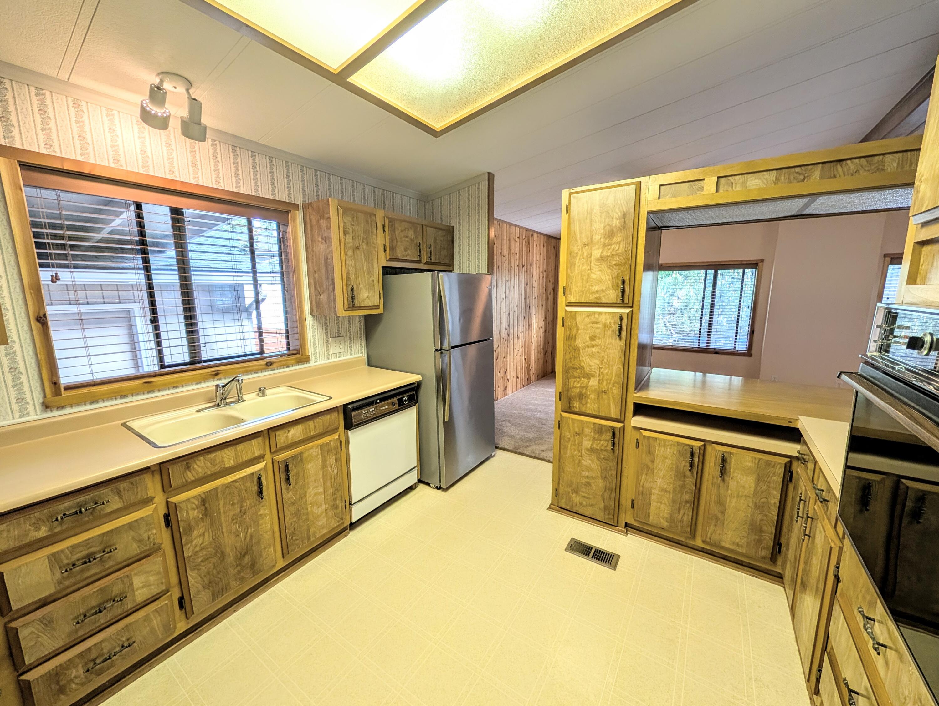 20735 Valentine Street, Unit 6 Bend, OR 97701 - Photo 5 of 26 a large kitchen with stainless steel appliances granite countertop a sink and a stove