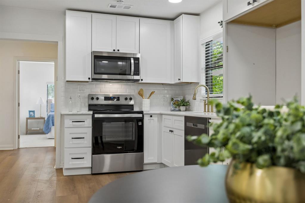 806 North Ruddell Street Denton, TX 76209 - Photo 16 of 26 a kitchen with stainless steel appliances a stove a microwave and a sink
