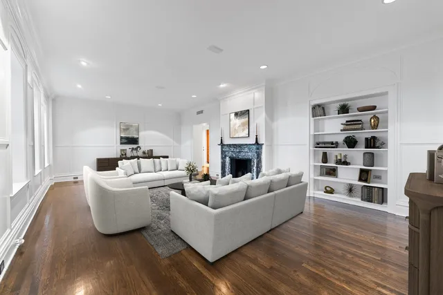 a living room with furniture white wooden floor and a chandelier