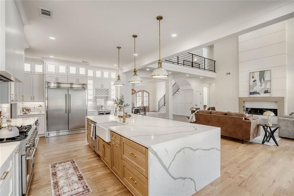 936 Cooper Road Loganville, GA 30052 - Photo 12 of 34 a large kitchen with kitchen island a large counter space a sink stainless steel appliances and cabinets