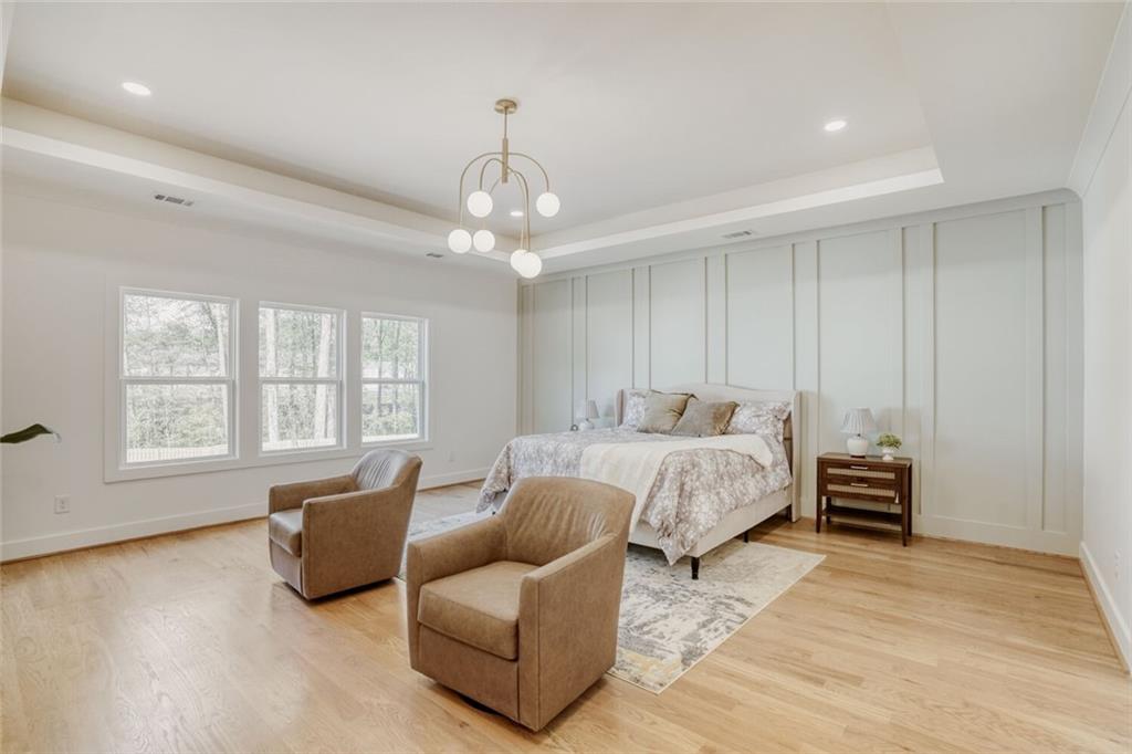 936 Cooper Road Loganville, GA 30052 - Photo 16 of 34 a spacious bedroom with a bed and wooden floor
