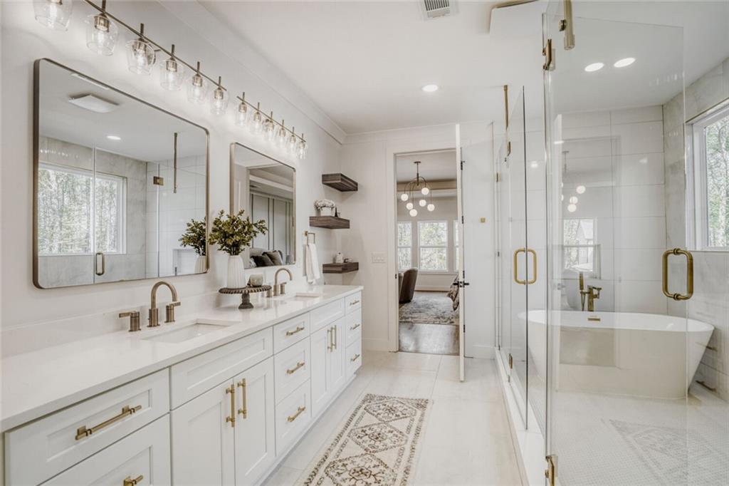 936 Cooper Road Loganville, GA 30052 - Photo 19 of 34 a spacious bathroom with a double vanity sink mirror double and shower