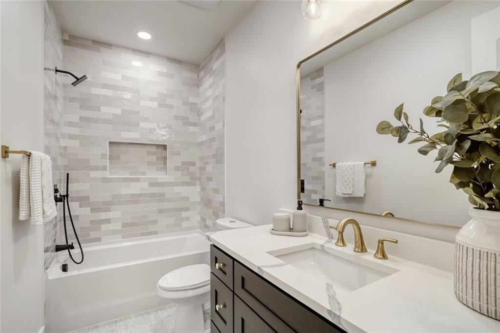 936 Cooper Road Loganville, GA 30052 - Photo 23 of 34 a bathroom with a granite countertop sink a toilet and shower