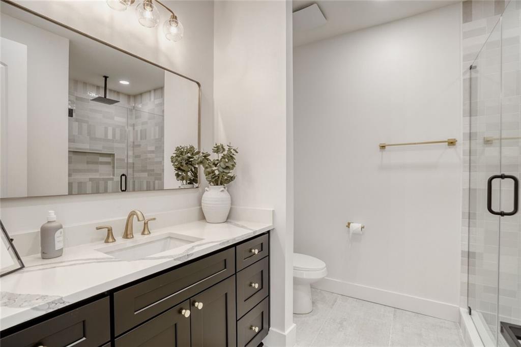 936 Cooper Road Loganville, GA 30052 - Photo 25 of 34 a bathroom with a granite countertop sink toilet and shower