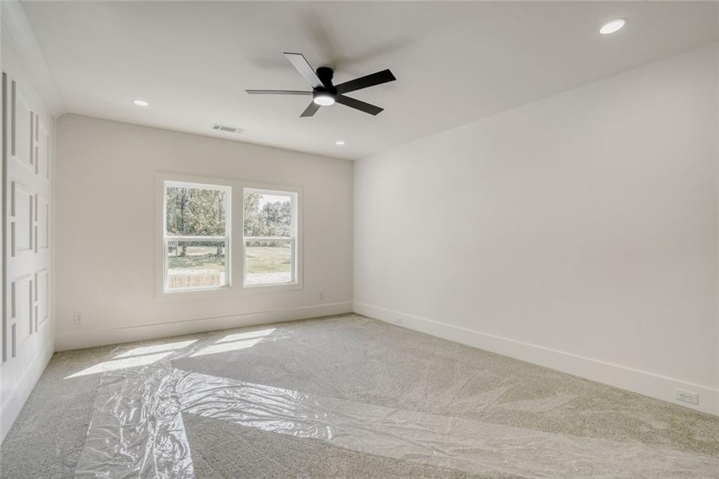 936 Cooper Road Loganville, GA 30052 - Photo 26 of 34 a view of a big room with windows and chandelier fan