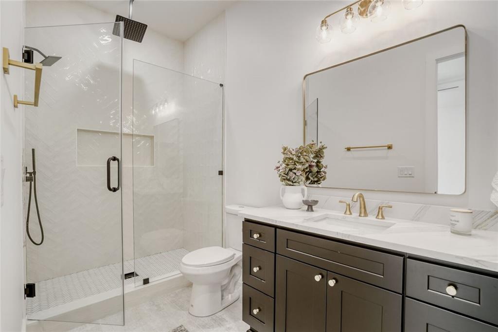 936 Cooper Road Loganville, GA 30052 - Photo 27 of 34 a bathroom with a shower sink vanity mirror and toilet