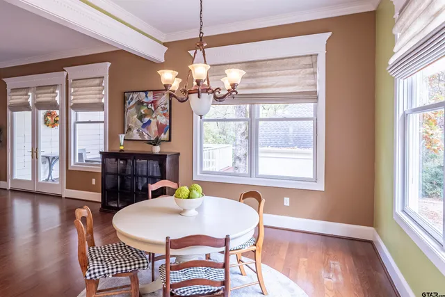 a view of a dining room with furniture a chandelier and wooden floor